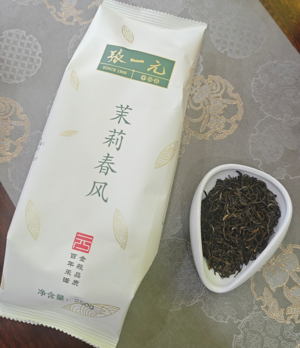 Zhang Yiyuan Moli Chunfeng jasmine tea 250g pack beside loose tea leaves